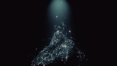 A Dark Background With A Light Shining On A Pile Of Papers GIF