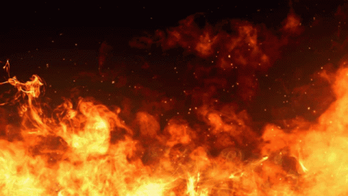 A Dark Background With A Lot Of Fire And Smoke Coming Out Of It GIF