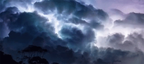 A Dark Cloudy Sky With A Lightning Bolt Coming Out Of It GIF