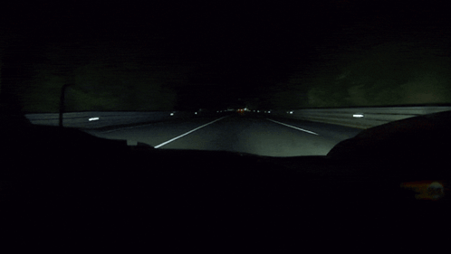 A Dark Highway With A White Line On The Right GIF