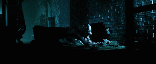 A Dark Room With A Brick Wall And A Hole In The Floor GIF