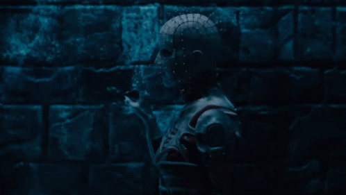a dark room with a brick wall and a statue of a skeleton