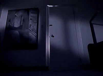A Dark Room With A Door Knob And A Shadow On The Wall GIF