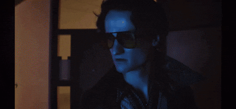 A Dark Room With A Door Open And A Window GIF