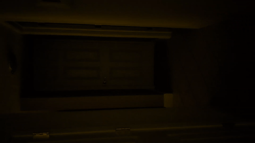 A Dark Room With A Few Lights On And A Person Walking Down The Stairs GIF