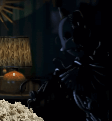 A Dark Room With A Lamp And Popcorn On The Table GIF