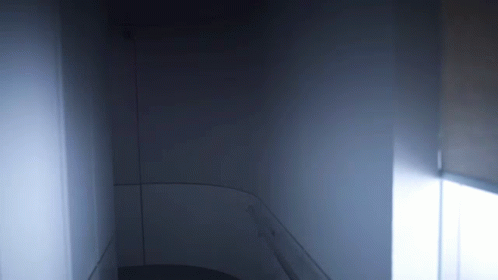 A Dark Room With A Light Coming Out Of The Window GIF