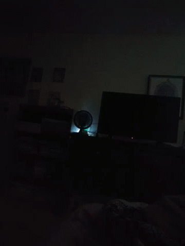 a dark room with a picture on the wall