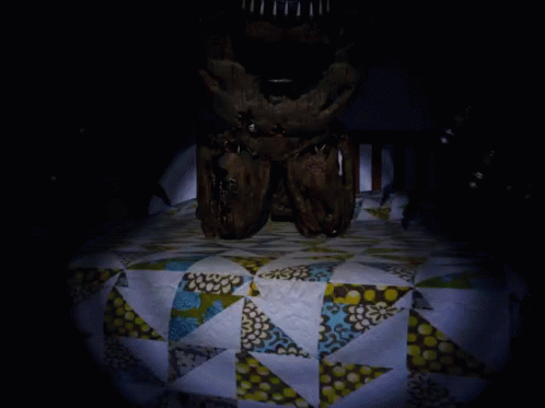 A Dark Room With A Quilt On The Floor GIF