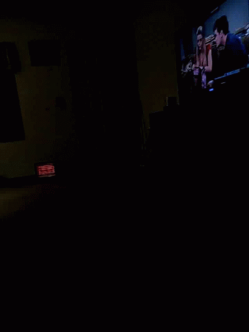A Dark Room With A Red Sign That Says Exit On It GIF