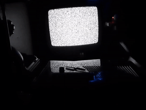 A Dark Room With A Tv That Has A Lot Of Static GIF