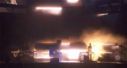 A Dark Room With Smoke Coming Out Of It And A Few Lights GIF