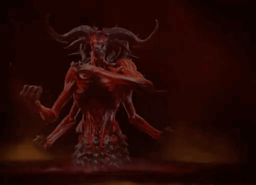 A Demon With Horns Is Holding A Skull In His Hands . GIF