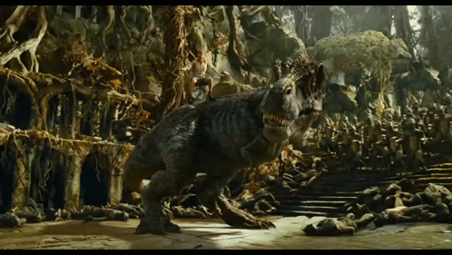 A Dinosaur Is Walking Through A Cave With A Lot Of Trees GIF