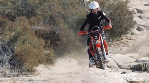 A Dirt Bike Rider Wearing A Helmet And Goggles Rides Through The Dirt GIF