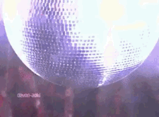 A Disco Ball Is Hanging From The Ceiling In Front Of A Crowd . GIF