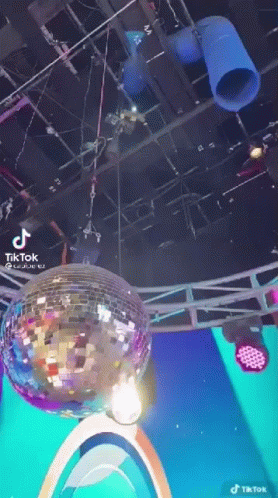 A Disco Ball Is Hanging From The Ceiling Of A Room . GIF