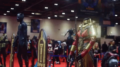 A Display Of Costumes At A Convention Has A Sign That Says 90 GIF