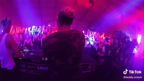 a dj playing music in front of a crowd with a tiktok watermark on the bottom right