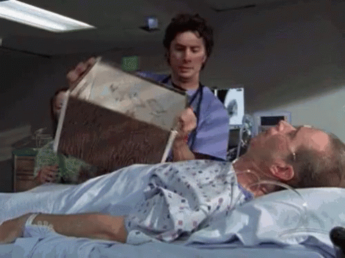 a doctor is reading a book to a patient in a hospital bed .
