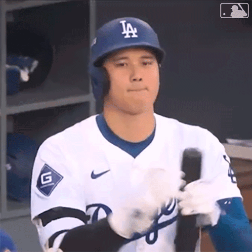 A Dodgers Baseball Player Is Holding A Bat In His Hand GIF