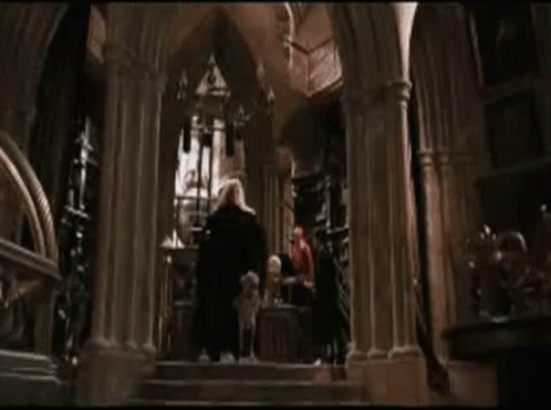 A Dog Is Laying On The Ground In Front Of A Man In A Cape . GIF