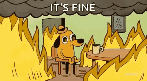 A Dog Is Sitting At A Table With A Cup Of Coffee In Front Of A Fire . GIF