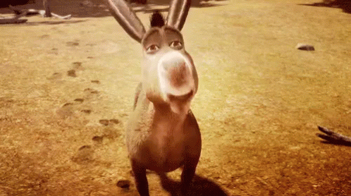 A Donkey From Shrek Is Standing On A Dirt Field Looking At The Camera . GIF