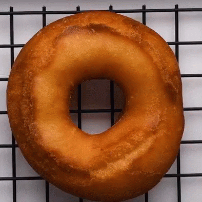 A Donut Is Sitting On A Wire Rack GIF
