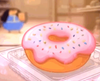 A Donut With Pink Frosting And Sprinkles Is In A Plastic Container On A Table . GIF