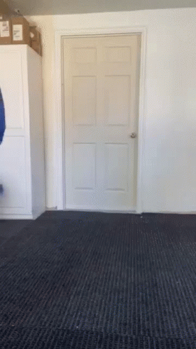 A Door In A Room With A Black Carpet And A Box On Top GIF