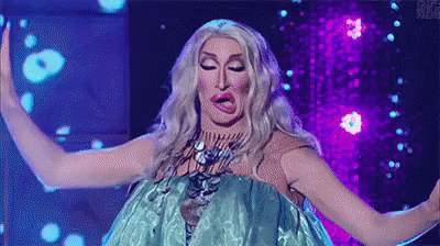 A Drag Queen Is Making A Funny Face While Wearing A Blue Dress On A Stage . GIF