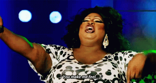 A Drag Queen Is Singing Into A Microphone And Saying `` You Make Me Feel '' GIF