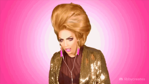 A Drag Queen Is Wearing Headphones And A Sequined Jacket With Libbycreates Written On The Bottom GIF