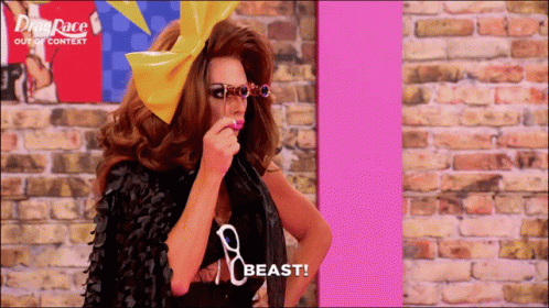 A Drag Queen Says Beast In Front Of A Drag Race Poster GIF
