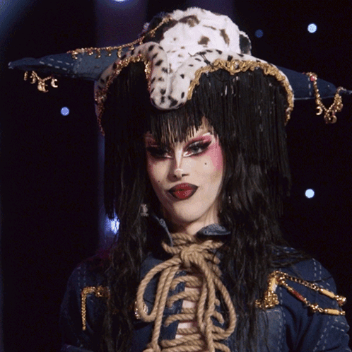 A Drag Queen Wearing A Dalmatian Hat Says " Evening Ma'am " GIF