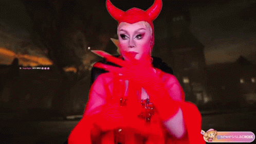 A Drag Queen Wearing A Red Devil Costume With Horns GIF