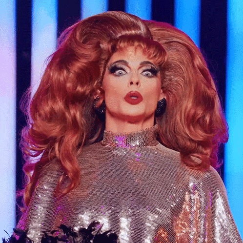 A Drag Queen With A Very Large Red Wig On GIF