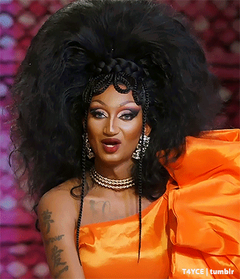 Drag Queen With Large Wig In Bright Orange Dress GIF