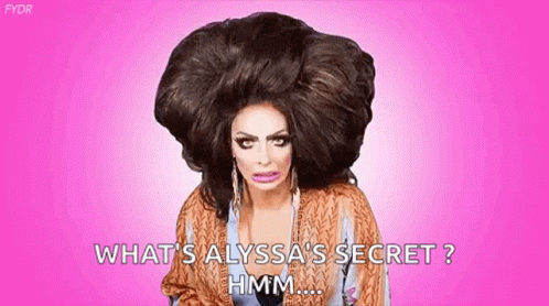 A Drag Queen With A Very Large Wig On Her Head Is Asking What 'S Alyssa 'S Secret . GIF