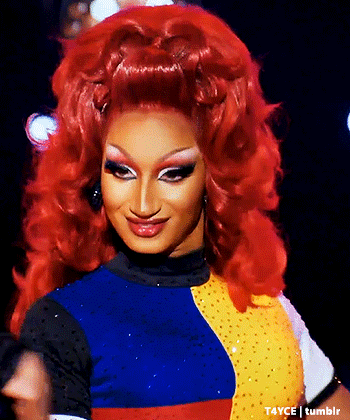 Drag Queen With Red Hair Smiling In Colorful Outfit GIF