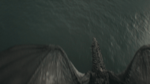 a dragon is flying over the ocean with its wings spread