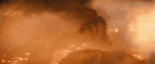 A Dragon Is Flying Through A Cloud Of Flames In The Sky . GIF