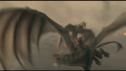 a dragon is flying through the air while a man is riding on its back .