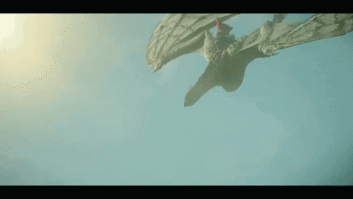 A Dragon Is Flying Through The Air With Its Wings Spread . GIF