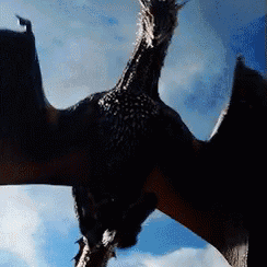 A Dragon With Its Wings Spread Is Flying In The Sky GIF