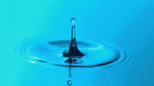 A Drop Of Water Falls Into A Blue Liquid GIF