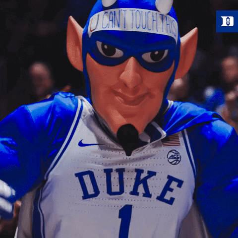 A Duke Basketball Mascot Wearing A Devil Costume And A Sign That Says " I Can 'T Touch This " GIF