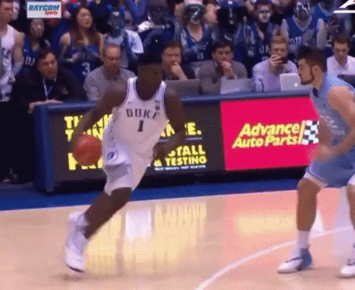 A Duke Basketball Player Dribbles The Ball In Front Of An Advance Auto Parts Ad GIF