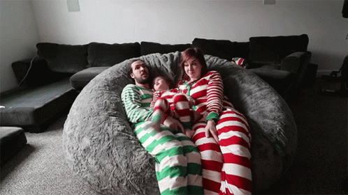 A Family Is Laying On A Bean Bag Chair Wearing Striped Pyjamas GIF